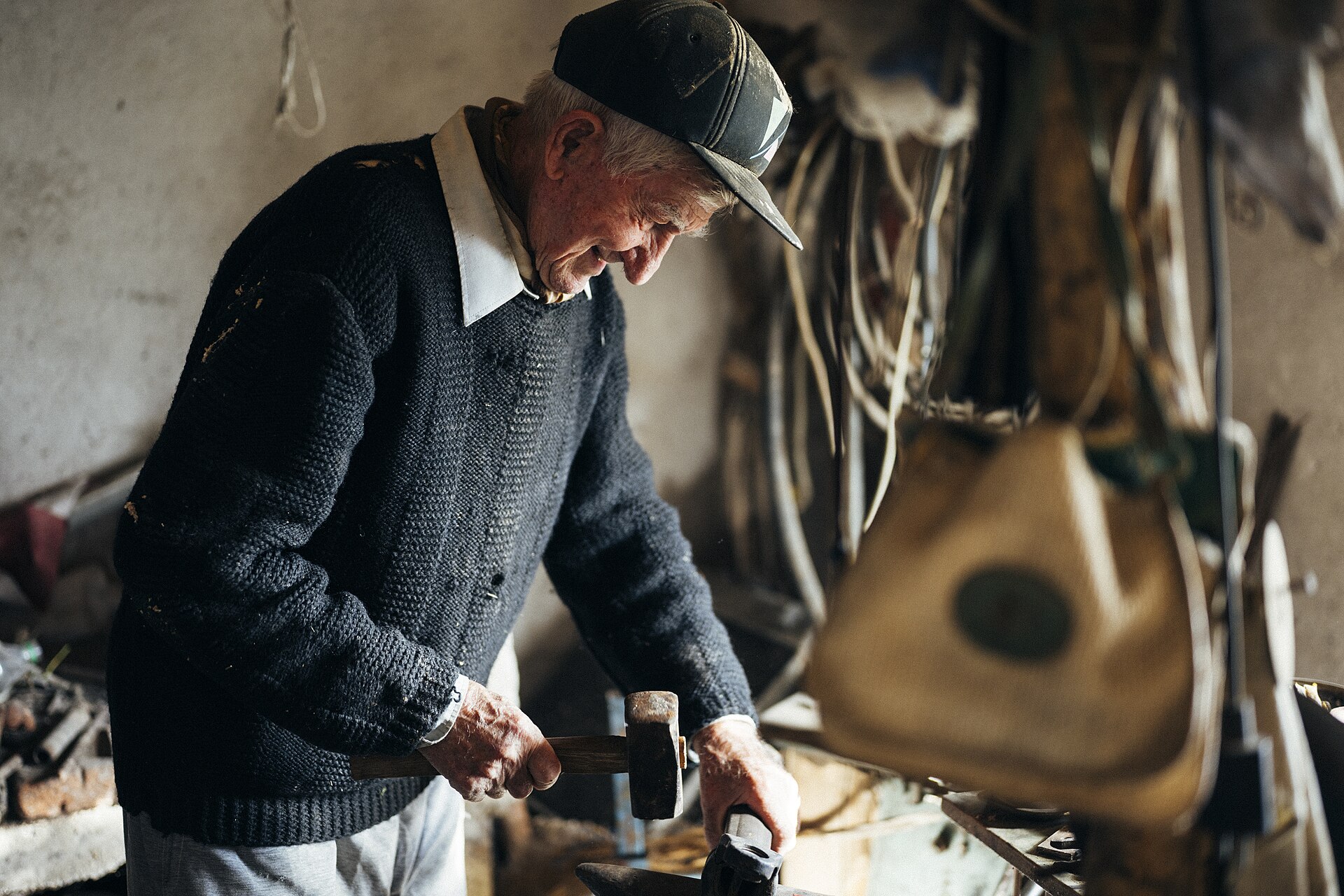 Ein älterer Handwerker arbeitet an seiner Werkbank