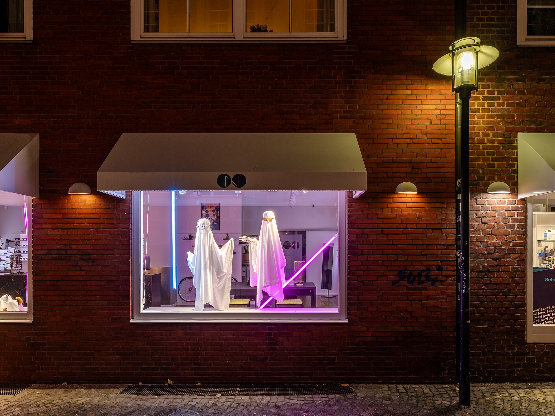 Beleuchtetes Schaufenster eines Fachgeschäfts am Abend