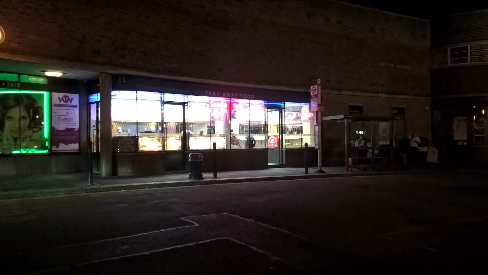 Ein hell erleuchteter Imbiss an einer dunklen Straße bei Nacht